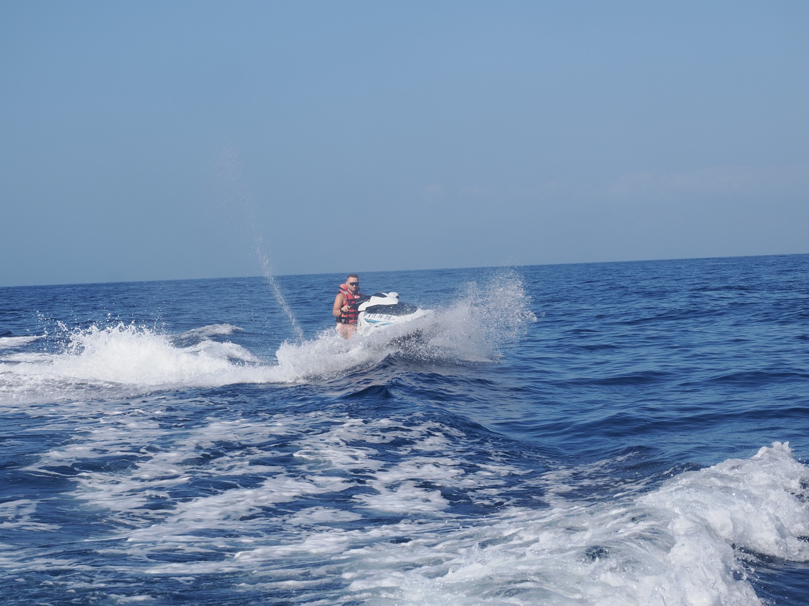 Jet ski throwing an arc of spray on a coastal safari